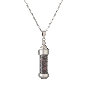 Détail du pendentif flacon de parfum argenté avec des pierres de grenat rouge foncé