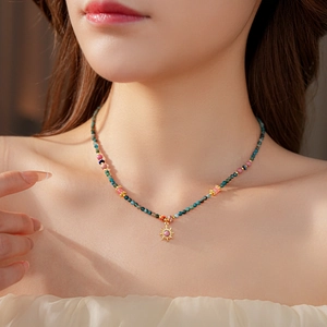 Gros plan d'un collier pendentif soleil avec des perles de pierre naturelle sur un mannequin