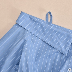 Detail of blue striped shirt collar with white button and precise stitching work