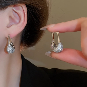 Gros plan de boucles d'oreilles élégantes en argent en forme de U avec zircons sertis