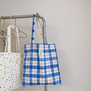 Detail of minimalist canvas tote bags with blue plaid and colorful polka dot patterns