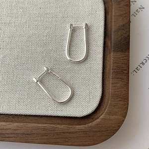 Minimalist S925 sterling silver U-shaped hoop earrings on elegant walnut tray