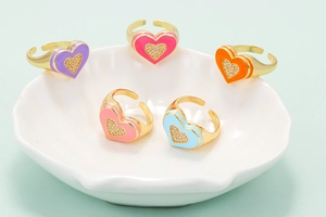 Detailed view of colorful heart-shaped rings with sparkling zircon and gold plating