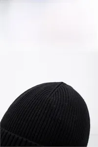 Detail of black knitted beanie showing thick ribbed texture and premium winter warm fibers