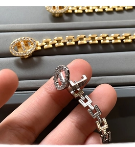 Detail of gold and silver chain bracelets with pave-set zircon buckle on display tray