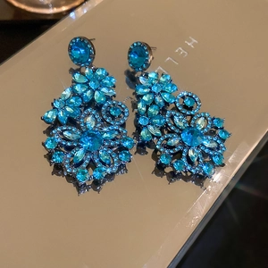 Detailed macro shot of blue crystal flower earrings with intricate rhinestone embellishments