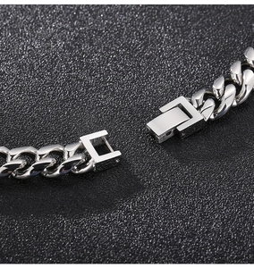 Macro detail of silver stainless steel Cuban link chain with secure box clasp closure