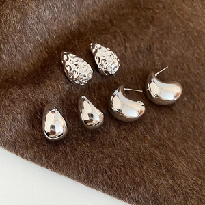 Detailed view of silver plated geometric teardrop earrings set with hammered textures