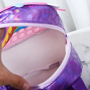 Detail of unicorn fidget backpack showing purple heart texture and rainbow pop it panel