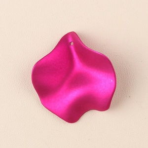 Macro detail of a wavy magenta acrylic petal charm with a single hanging hole