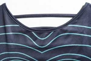 Détail du col en U avec bride décorative et imprimé rayures vagues vertes sur tissu gris