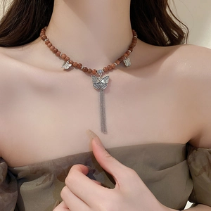 Collier vintage en perles de bois de santal avec papillons argentés et glands élégants