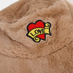 Détail du patch brodé cœur LOVE sur un chapeau bob en fausse fourrure marron