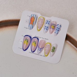 Close-up of handmade stiletto nails with 3D blue floral, orange fish, and lemon patterns