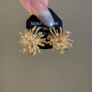 Macro shot of fireworks zircon clip-on earrings in 18k gold plating with sparkle.