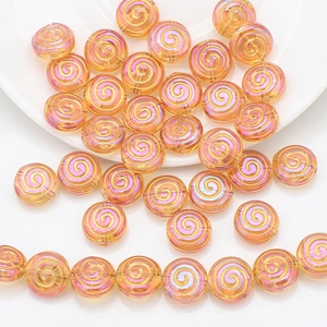 Detail of pink crystal glass beads with golden spiral patterns for DIY jewelry making