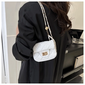 Detail of white quilted crossbody bag with gold chain strap and metal ball adjuster