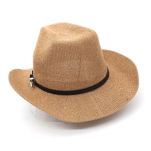 Gros plan sur la texture en paille tressée naturelle et ruban en cuir noir à boucle métal