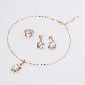 Detail of gold jewelry set featuring rectangular clear zircon pendants and crystals