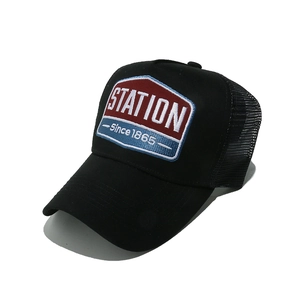 Macro detail of breathable mesh back and embroidered patch on black trucker hat