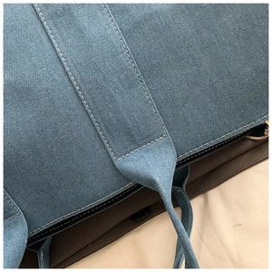 Detail view of durable blue denim tote with reinforced white double-stitching craftsmanship