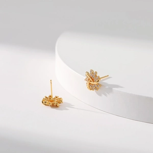 Elegant 18K gold plated snowflake stud earrings with sparkling diamonds on a white base