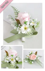 Detail view of light pink silk rose corsage with white flowers and green ribbon for weddings