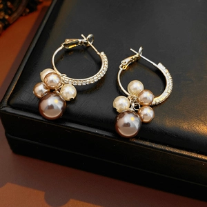 Détail de boucles d'oreilles vintage avec perles champagne et éclats de zircons cubiques