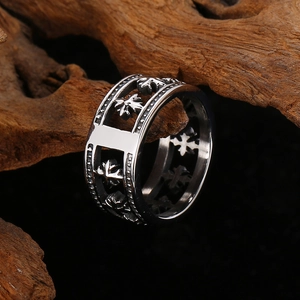 Détail d'une bague pour homme avec motif croix évidé en acier titane sur bois