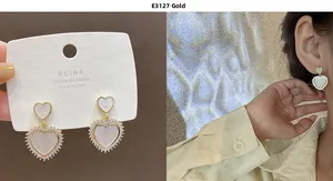 Detail of gold heart earrings with white mother-of-pearl and crystal rhinestones
