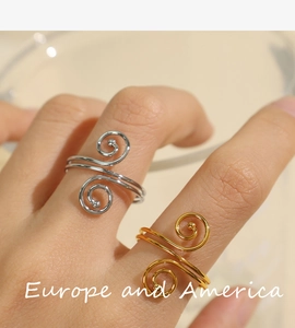 Close-up of stylish gold and silver spiral rings featuring minimalist twisted metal texture