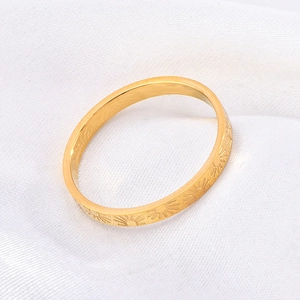 Detailed view of sunburst pattern engravings on a 18k gold plated stainless steel ring