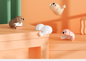 Paraspigoli in silicone a forma di cucciolo in quattro colori con retro adesivo
