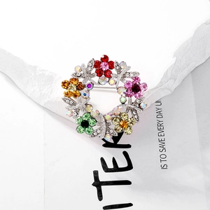 Detailed view of a silver wreath brooch with vibrant multicolored rhinestone embellishments
