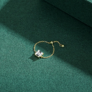 Bague chaîne élégante en argent s925 doré avec zircon carré sur fond texturé vert foncé