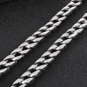 Macro shot of silver punk Cuban chain with intricate floral patterns on steel links