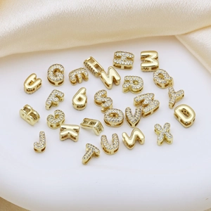 Detailed close-up of gold plated 26 alphabet pendants with pavé cubic zirconia on silk