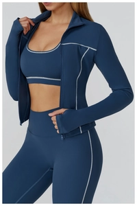 Detail of contrast stitching and thumbhole cuffs on navy blue slim yoga jacket