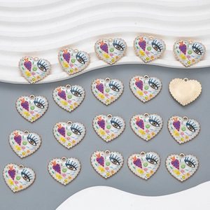 Flat lay of colorful heart enamel pendants with evil eye and floral motifs for DIY jewelry