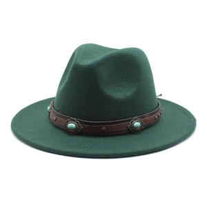 Détail du chapeau fedora vert foncé avec ruban en cuir brun et pierre turquoise ornée