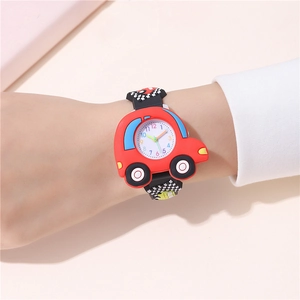 Close-up of a red cartoon car watch with black checkered silicone strap on a child wrist