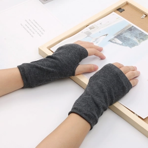 Gros plan de mitaines en tricot gris foncé portées sur un fond de style de vie épuré