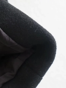 Detailed macro view of black wool coat fabric texture and inner lining construction