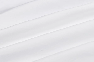 Macro detail of the white shirt fabric showing the smooth texture and fine weaving pattern