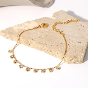 Detailed macro view of a gold beaded stainless steel bracelet with sparkling rhinestones