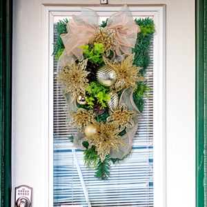 Goldener Weihnachtsbaum mit Kiefernnadeln, Blumen und champagnerfarbenen Schleifen