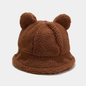 Close-up of thick brown faux lamb wool fabric and cute bear ears on the winter bucket hat
