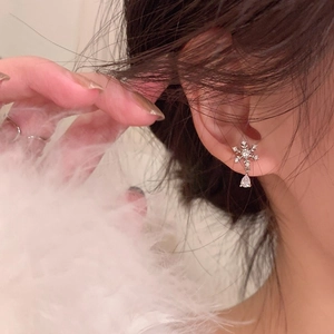 Boucles d'oreilles flocon en argent avec pendentif goutte en zircon portées par un mannequin