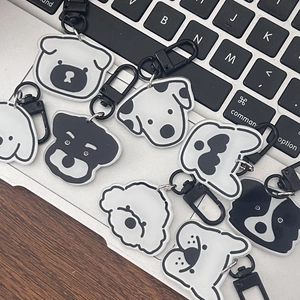 Detailed view of dog-themed acrylic keychains featuring various breeds on a laptop surface