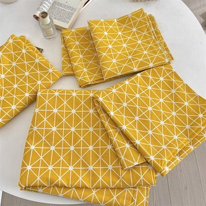 Detailed macro view of yellow geometric cotton linen napkins stacked on a white table